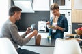 Serious and unhappy young couple eating while using smartphone in the kitchen at home Royalty Free Stock Photo