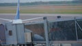 Silhouette of two passengers boarding on airplane through an airbridge.