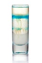 Shot sliced alcohol cocktail with blue drops isolated on white