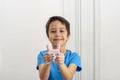 Smiling little boy wearing a blue shirt washing hands with pink soap