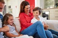 Family bonds. Shot of smiling parents sitting with their young son and daughter on their living room sofa at home. Royalty Free Stock Photo