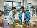 Whatcha got cooking. Shot of a smiling young couple preparing a meal together in their kitchen. Royalty Free Stock Photo