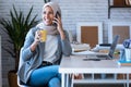 Smiling young muslim business woman wearing hijab talking with mobile phone sitting in the office Royalty Free Stock Photo