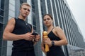 Sporty couple together looking at camera outdoors in city