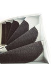 Shot of staircase turn or curve. Gray steps with carpet runners