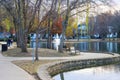 A shot of the still lake water in the park surrounded by gorgeous autumn colored trees reflecting off the water with blue sky