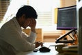 Shot stressed male software developer programming code on computer screen