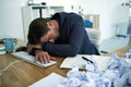 Drowning in paperwork. Shot of a stressed out businessman passed out at his desk overwhelmed by paperwork. Royalty Free Stock Photo