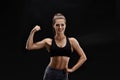 Shot of a strong woman with muscular abdomen in sportswear. Fitness female model posing on black background. Royalty Free Stock Photo