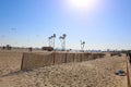 A shot of a sunny day at the beach with people flying kites and blue sky