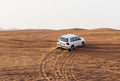 Shot of a SUV vehicle driving trough sand dunes. Desert