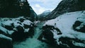 A stream of water, a small waterfall, in the winter scenery in the mountains, Valldal, More og Romsdal, Norway 2019, 4K