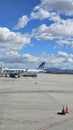 A shot of the tarmac at the Ontario International Airport with planes and runways, blue sky and clouds in Ontario California Royalty Free Stock Photo