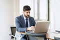 Shot of thinking businessman sitting behind his laptop while working at the office Royalty Free Stock Photo