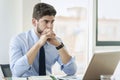 Shot of thinking businessman sitting behind his laptop while working at the office Royalty Free Stock Photo