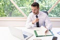 Shot of thinking businessman sitting at desk and using laptop while working at the office Royalty Free Stock Photo