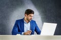 Shot of thinking businessman using laptop while sitting in the office and working Royalty Free Stock Photo