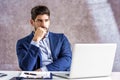 Shot of thinking businessman using laptop while sitting in the office and working Royalty Free Stock Photo