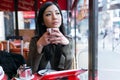 Thoughtful young asian woman drinking coffee in the terrace of a coffee shop. Royalty Free Stock Photo