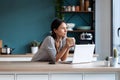 Thoughtful young woman looking to the side while holding a cup of coffee in the kitchen at home Royalty Free Stock Photo