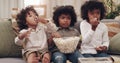 Whats a movie without snacks. Shot of three adorable little boys eating popcorn and watching movies together at home. Royalty Free Stock Photo