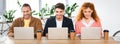 Shot of three smiling friends using laptops in office Royalty Free Stock Photo