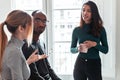 Three young business people drinking coffee while taking a break in the office Royalty Free Stock Photo