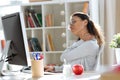 Tired young business woman having neck and back pain while working with computer in the office Royalty Free Stock Photo