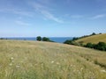 A shot between to valley hills looking out to sea on a summers beneath feathered clouds in a pale blue sky,Dawlish, Devon, UK Royalty Free Stock Photo