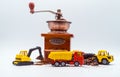 A toy excavator loads coffee beans into the back of a toy truck with a bucket, and a toy bulldozer rakes roasted coffee beans into Royalty Free Stock Photo