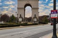 A shot of the Triumphal arch at the Millennium Gate Museum with African Americans underneath surrounded by buildings