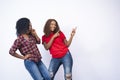 Shot of two beautiful black females pointing to the space to their side - advertisement concept Royalty Free Stock Photo