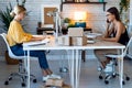 Two beautiful freelance business women seller working with computer while talking with smart phone in their startup small business Royalty Free Stock Photo