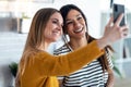 Two beautiful woman friends having breakfast and drinking coffee while talking in the kitchen at home Royalty Free Stock Photo