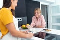 Two beautiful women tasting the healthy dishes they have prepared in the kitchen at home