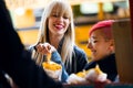 Two beautiful young women buying barbecue potatoes on a food truck in the park. Royalty Free Stock Photo