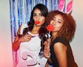Making it a night they wont forget. Shot of two beautiful young women having fun with props in a photobooth.
