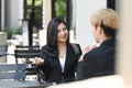 Businesspeople having a discussion while sitting outdoor coffee shop. Royalty Free Stock Photo