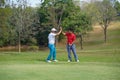 Shot of two golfers congratulating each other with a high five after a game of golf