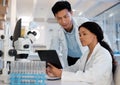 Double the brain power. Shot of two lab techs working together while using a digital tablet. Royalty Free Stock Photo