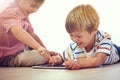 He has so much fun online. Shot of two little boys using a digital tablet together while sitting on the floor. Royalty Free Stock Photo