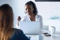 Two pretty young business women working with digital tablet and laptop in the office Royalty Free Stock Photo