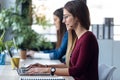 Two young business women friends working together with laptop while talking in the office at home Royalty Free Stock Photo