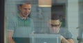 Shot of two young male office employees or colleagues are discussing and working together in front of computer monitor Royalty Free Stock Photo