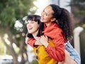 Make a smile your signature accessory. Shot of two young women enjoying a piggyback ride outdoors. Royalty Free Stock Photo