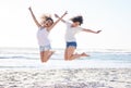 Celebrate your friendship everyday. Shot of two young women jumping for joy at the beach. Royalty Free Stock Photo