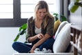 Uncomfortable young woman scratching her arm while sitting on the sofa at home Royalty Free Stock Photo