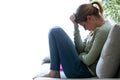 Unhappy lonely depressed young woman sitting on sofa at home. Depression concept.