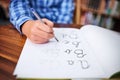 Practising his handwriting. Shot of an unrecognisable young boy writing in a book at school.