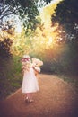 I wonder where this leads. Shot of a unrecognizable little girl walking with her teddy bear in the middle of a dirt road Royalty Free Stock Photo